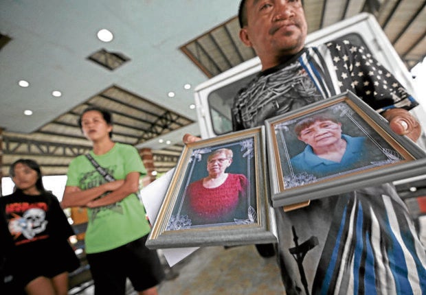 PRINCESS AYA / JULY 28, 2023A funeral worker prepares the portraits of the victims to be send to Talim Island from Binangonan Port in Rizal province. At least 26 passengers were killed after the passenger boat capsized due to strong winds and heavy rain brought Typhoon Egay. INQUIRER PHOTO / RICHARD A. REYES