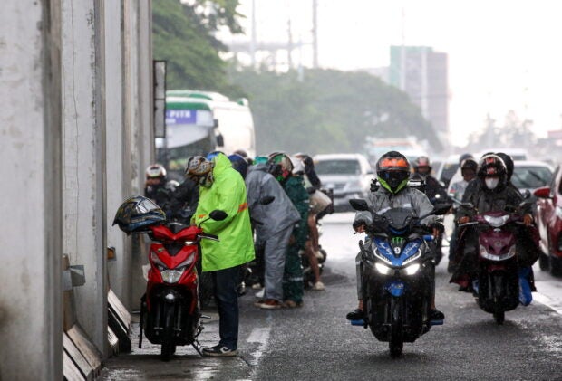 NOT WATERPROOF   Motorcycle riders take shelter under an MRT station. —LYN RILLON